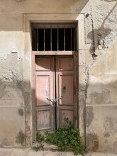 Sicilian Still Life: Chained Faded Red Doors Of Ancient Stone Cellar