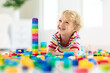 © famveldman - Child playing with toy blocks. Toys for kids.