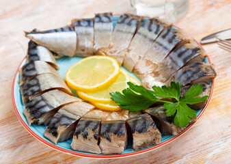 Tasty healthy smoked mackerel with parsley and lemon on the dining table. High quality photo