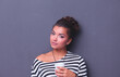 © lenets_tan - Young woman standing with cup, isolated on gray background. Young woman