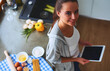 © lenets_tan - Woman baking at home following recipe on a tablet