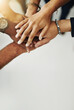© Delmaine Donson/peopleimages.com - Hands in a huddle for teamwork, unity and working together from above. Closeup of a diverse group or team collaborating, joining and connected as a united people, showing solidarity and cooperation