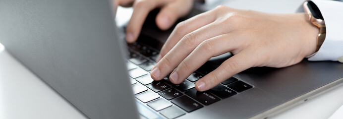 Wall Mural - Businesswoman's hand presses on a laptop keyboard, World of technology and internet communication, Using computers to conduct financial transactions because the convenience and speed.