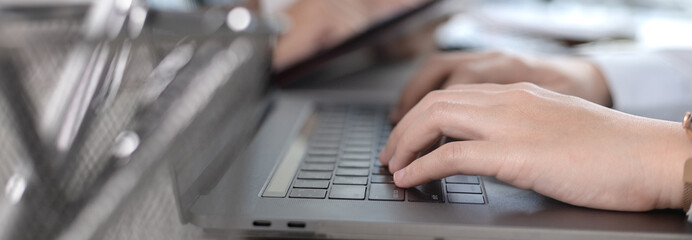 Wall Mural - Businesswoman's hand presses on a laptop keyboard, World of technology and internet communication, Using computers to conduct financial transactions because the convenience and speed.