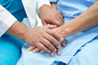 © manassanant - Doctor holding hands Asian elderly woman patient, help and care in hospital.