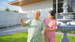 Old elderly Asian patient or pensioner people walking by walker with a nurse, relaxing, in nursing home in garden park. Senior lifestyle activity recreation. Retirement. Health care physical therapy.