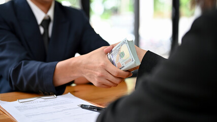 Businessman giving an illegal money or bribe money to his business dealer