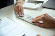 © bongkarn - A male client giving a house loan payment or mortgage fees to his real estate agent.