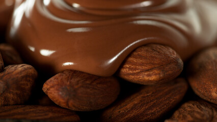 Pouring melted chocolate on almonds.