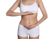© New Africa - Woman in underwear holding something near her belly on white background, closeup. Healthy stomach