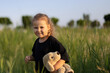 © olga - a little girl with a toy in a green field. naughty little girl