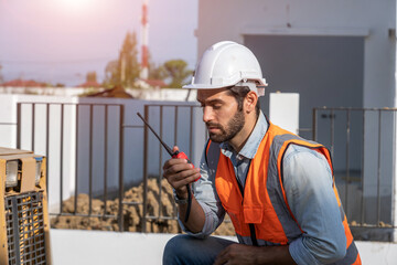 Poster - Professional worker talking by walkie talkie checking and working at construction site of the housing project.