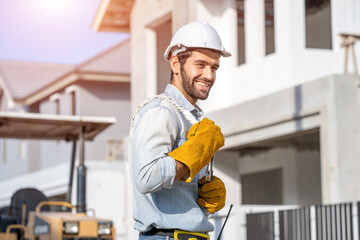 Wall Mural - Technician wearing safety helmet standing at a construction site,Concept of architect profession and house building.