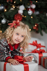 Wall Mural - Happy excited girl child holding christmas gift box. Child giving a Christmas present in decorated room. christmas and people concept. New Year Happy holidays. kid satisfied with present.