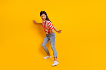 Wall Mural - Full body portrait of overjoyed lady dancing partying toothy smile isolated on yellow color background