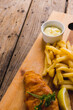 High angle view of french fries with seafood and sauce on wooden board, copy space
