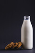 Milk bottle with cookies against gray background with copy space