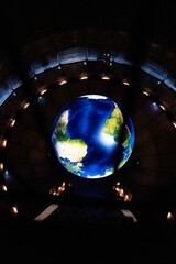 Wall Mural - Vertical view of a glowing installation of the Earth in a tunnel