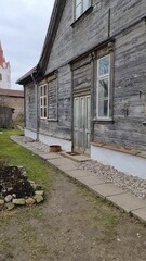 Wall Mural - Walk through the streets of the old town of Cesis in Latvia. Sunny spring day. Walk through the streets of the old town of Cesis in Latvia. Old wooden one-story houses and a simple way of life. Vertic