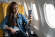Beautiful asian travel woman take a selfie with mobile phone in airplane