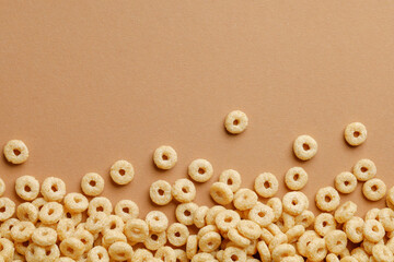 Wall Mural - Cornflakes rings for breakfast on a brown background.