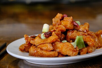 Closeup shot of an orange chicken Chinese food on a white plate