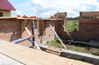 © Andrey - Construction of a brick and wooden roof house construction in progress