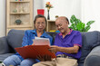 © khunkornStudio - Senior asian couple talking happy planing retirement insurance health care contract on sofa.