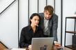 © Julia Jones - a man and a woman in the office are working at a laptop and smiling