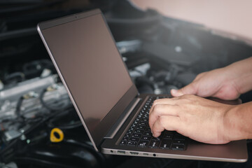 Wall Mural - Mechanic using computer laptop for diagnostics engine. Repairing car Check various operating systems to check for abnormalities, service concept and technology