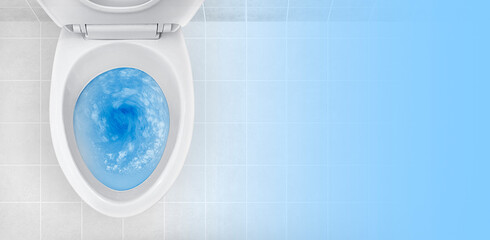 Top view of toilet bowl, blue detergent flushing in it