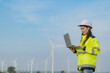 © reewungjunerr - women engineer working and holding the report at wind turbine farm Power Generator Station on mountain,Thailand people