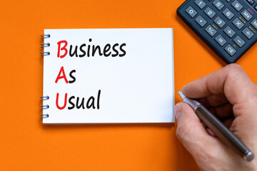 bau business as usual symbol. concept words bau business as usual on white note on a beautiful orang