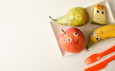 Background with funny fruit plate served for children on table