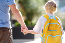 Little Schoolboy With His Father Goes To School After Summer Holiday. Parent Accompanies Or Meets The Child. Education For Children. Kids Back To School Concept.
