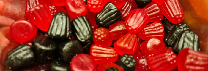 Red black gelatins in form of berries closeup