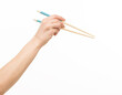 © serhii - hand holding chopsticks on white background isolated