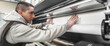 © guruXOX - Technician operator changes paper roll on large printer plotter machine