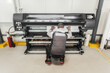 © guruXOX - Technician operator changes paper roll on large printer plotter machine