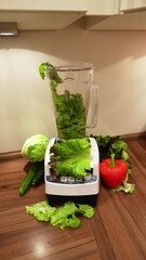 Wall Mural - Man making a green smoothie with lettuce and vegetables