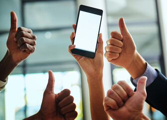 Wall Mural - Thumbs up, support and blank phone screen shown by professional corporate business people in an office together. Employees and colleagues showing agreement while holding a device with information