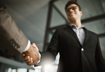 Leinwandbilder - Below of two business peoples handshake during a meeting in an office. Colleagues finalize a successful promotion, deal and merger. Coworkers greet while collaborating and negotiating in interview