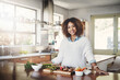 Leinwandbild Motiv Wellness, cooking and a healthy lifestyle at home with a happy woman starting a weight loss journey. Portrait of a female smiling preparing a nutritious meal with organic vegetables in a kitchen