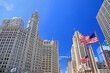Wrigley Building and Tribune Tower on Michigan Avenue with Illinois flag on the foreground in Chicago, USA