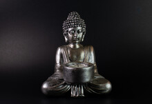 Buddha Statue With Lit Candle. Black Background