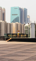 Wall Mural - Young woman takes a picture of a modern city. Urban