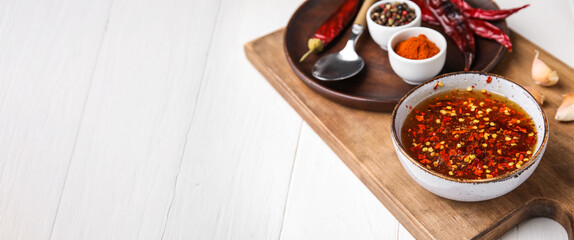 Bowl of hot honey sauce on white wooden background with space for text