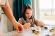 © Olga Krivokoneva - Happy kids cooking cookies bakery together and having fun with flour indoors at cozy home on the kitchen table. Siblings in big loving family