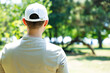 © dragonstock - Back view of young man wearing a white baseball cap in the park