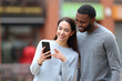 © PheelingsMedia - Happy interracial couple checking cell phone